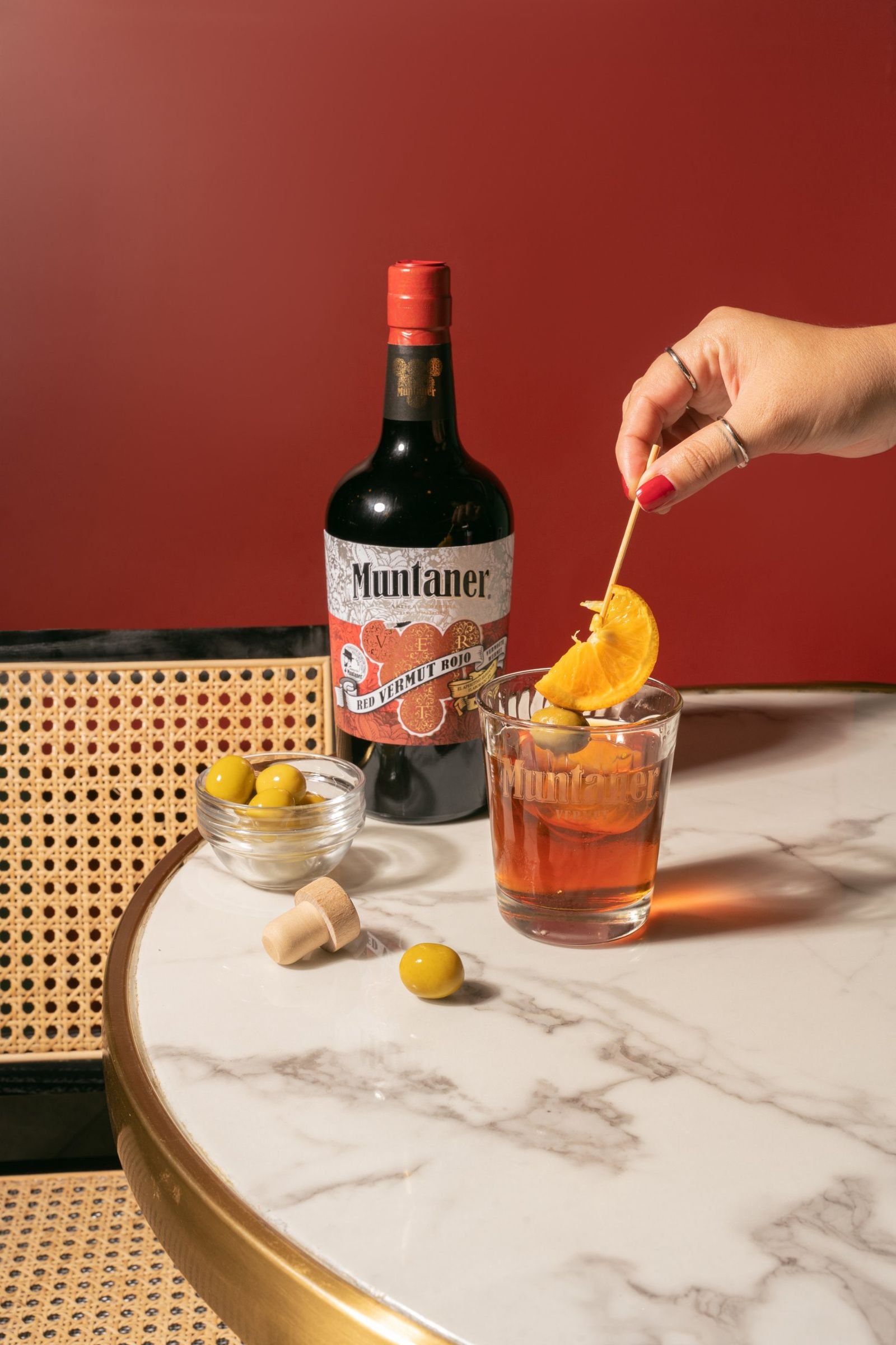 Fotografía de producto de vermut Muntaner con vaso, naranja y aceitunas