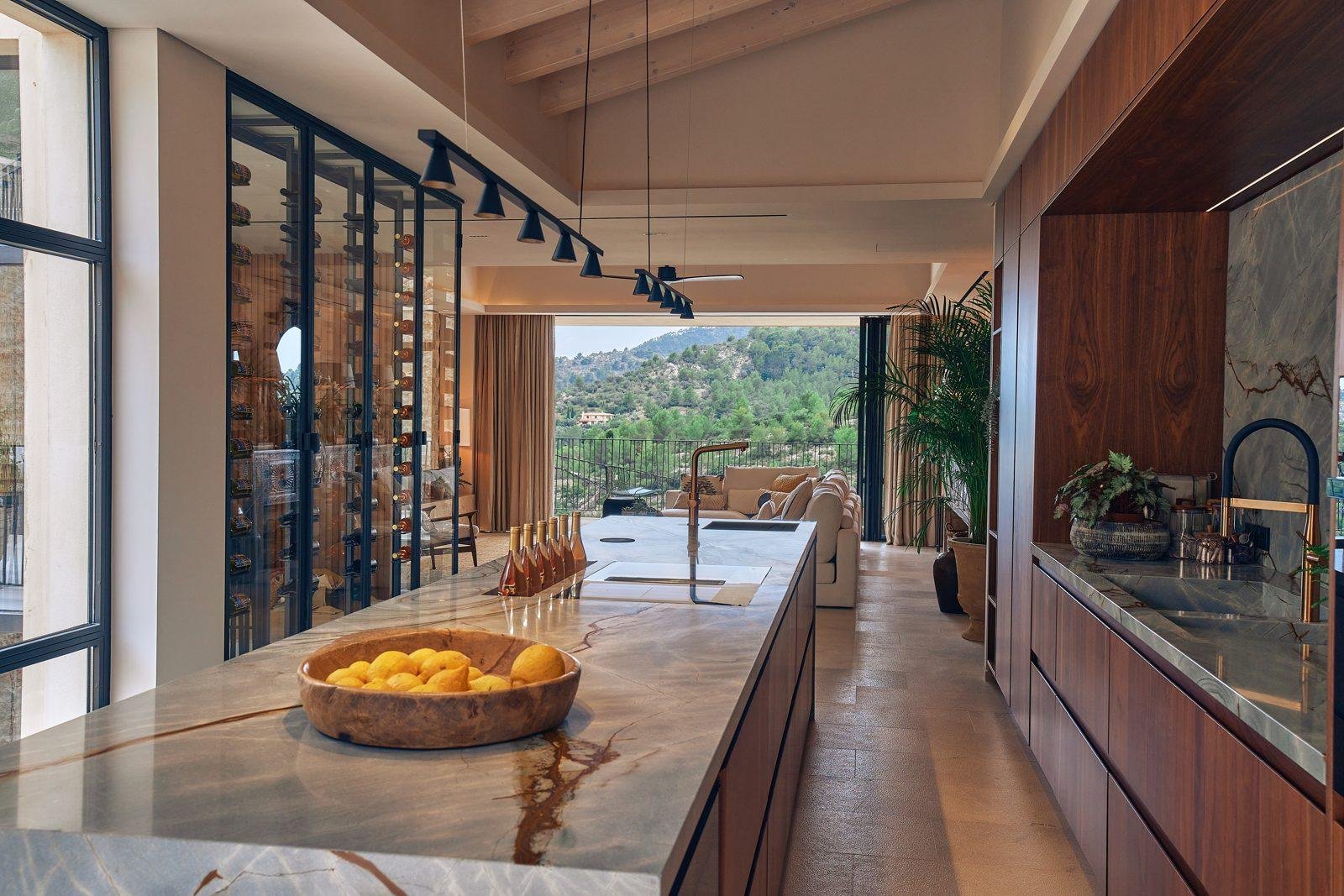 Cocina con isla de mármol y bodega acristalada