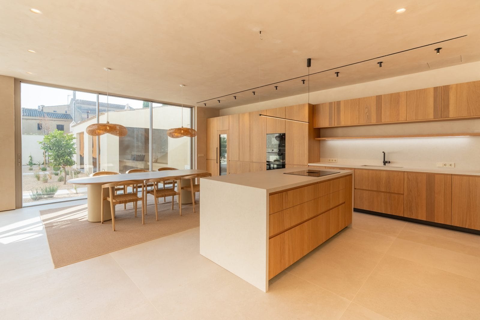 Cocina de madera con isla y comedor abierto al jardín