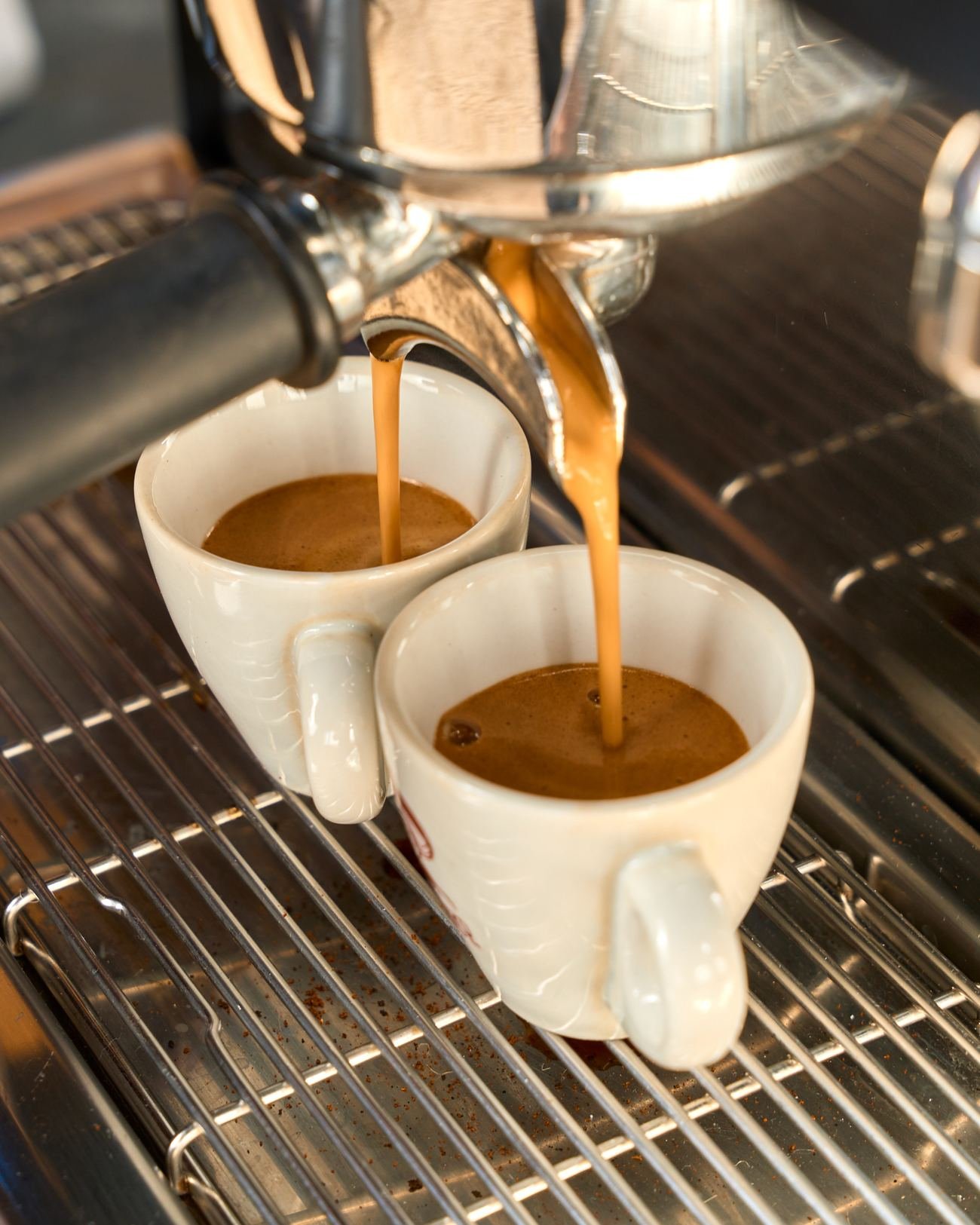 Espresso doble cayendo en dos tazas