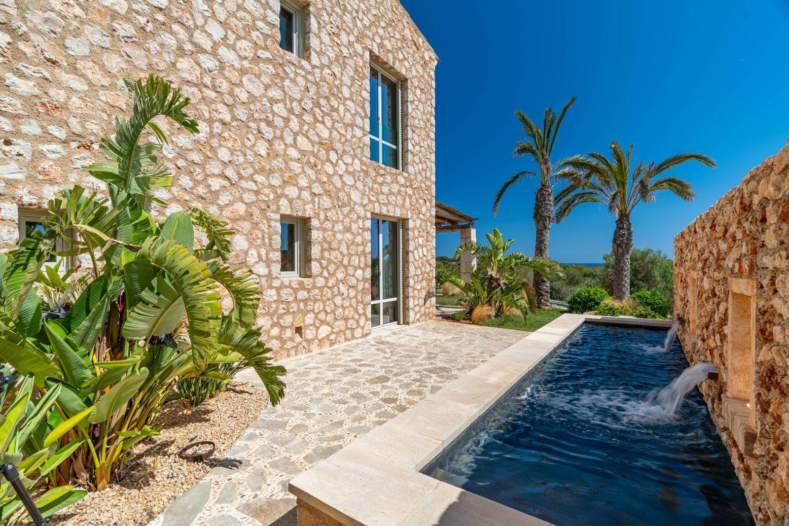 Finca de piedra con piscina y palmeras