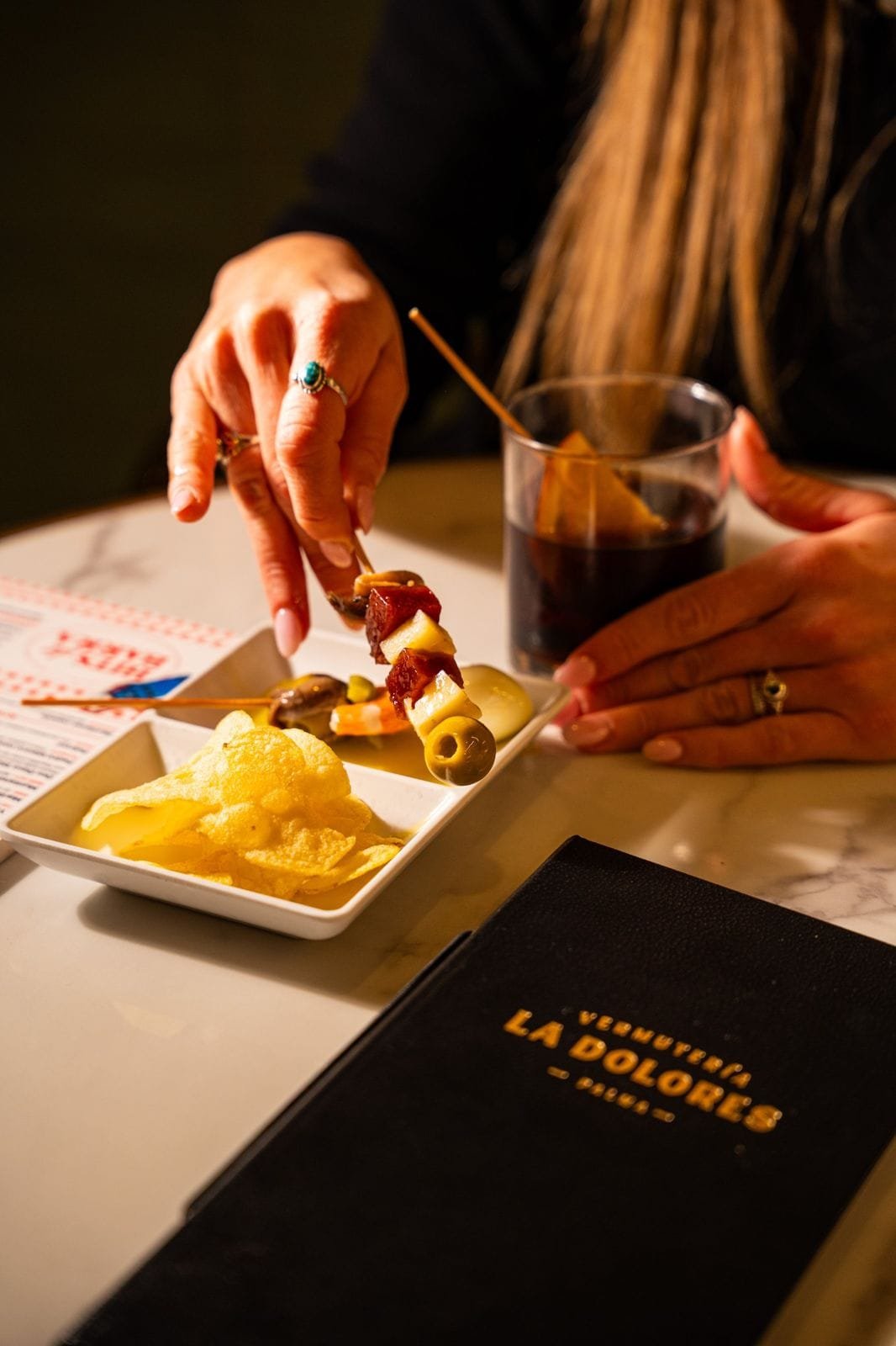 Gilda, patatas y vermut junto a la carta de La Dolores