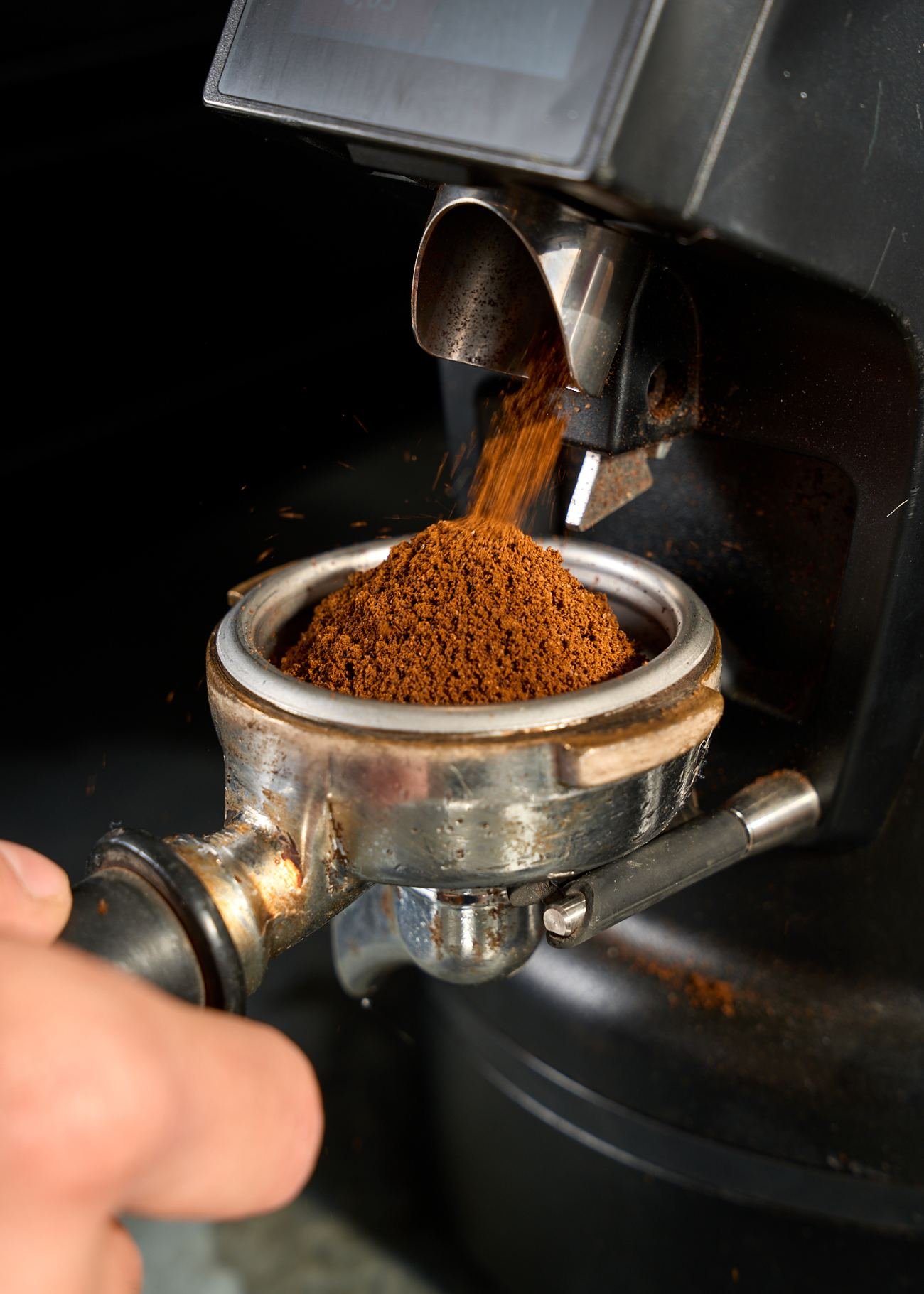 Café recién molido cayendo en el portafiltro