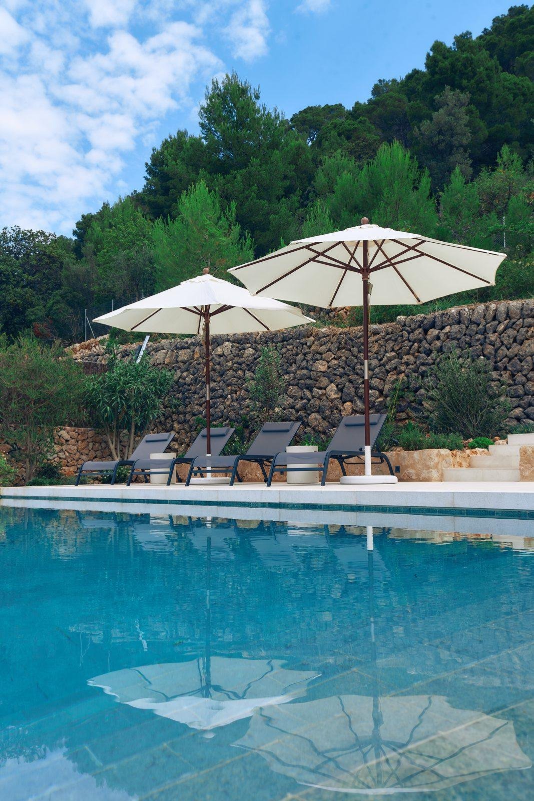 Piscina con hamacas y sombrillas en una villa de Mallorca