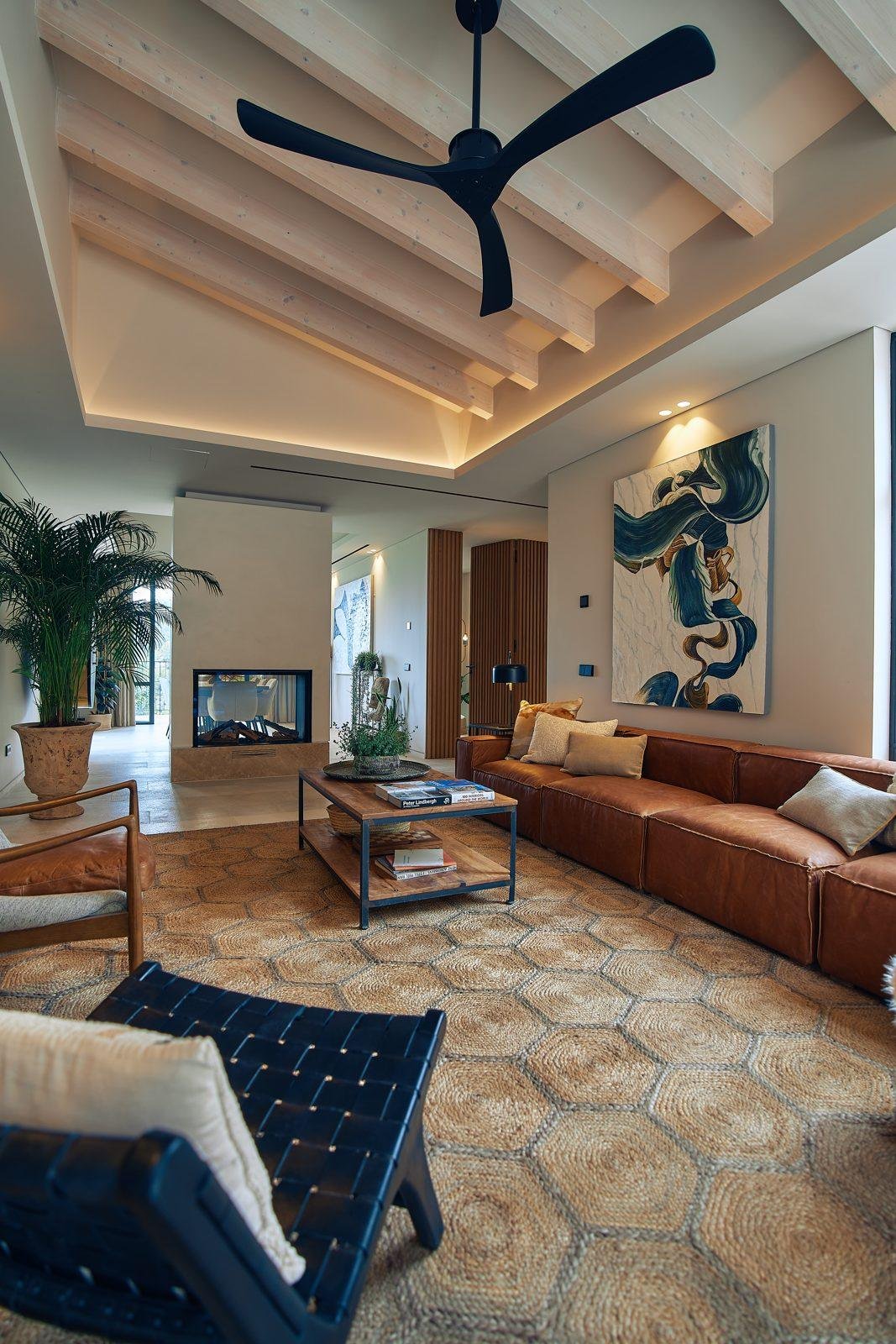 Salón con sofá de cuero y techo de vigas en una villa de Mallorca