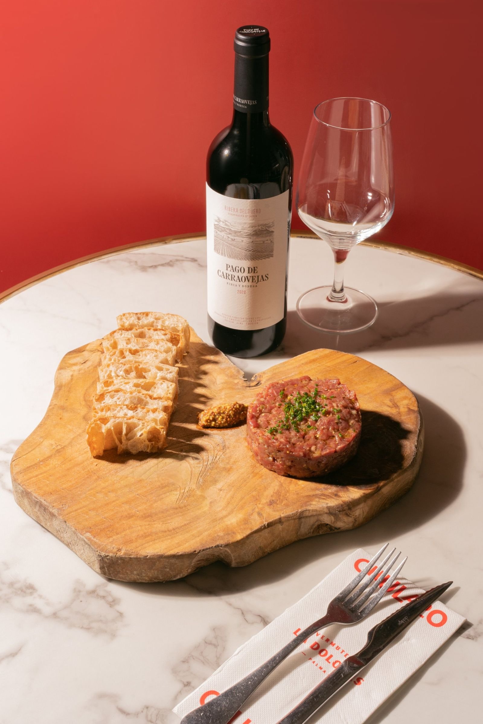Fotografía gastronómica de steak tartar con botella de vino tinto en Palma