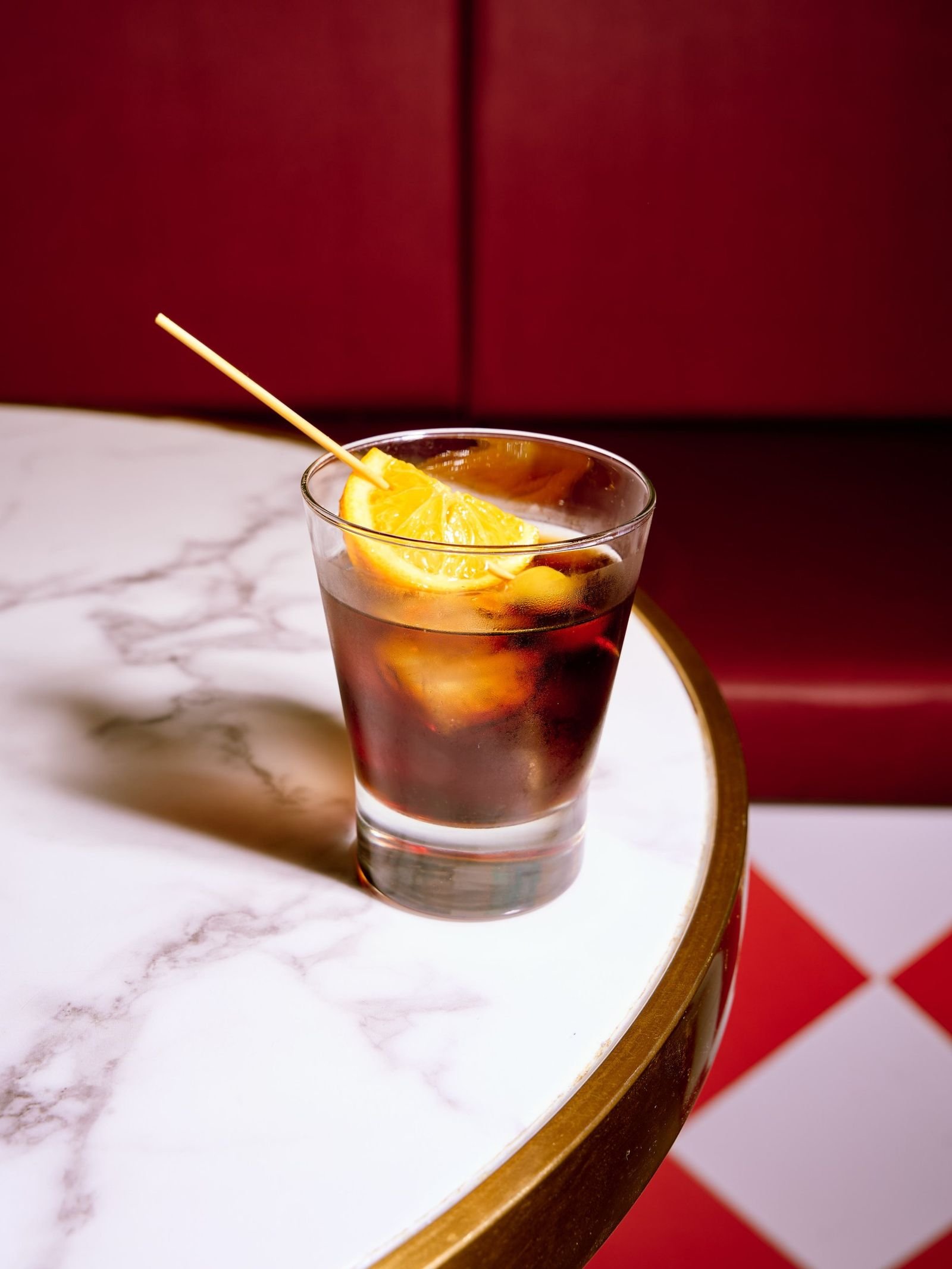 Fotografía de bebidas: vaso de vermut con naranja sobre mesa de mármol en Palma